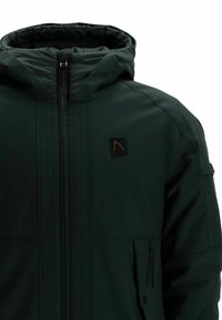 Zelena jakna z zadrgo spredaj, kapuco in črnimi detajli. Narejena iz gladkega, vodoodpornega materiala z stranskimi žepi.