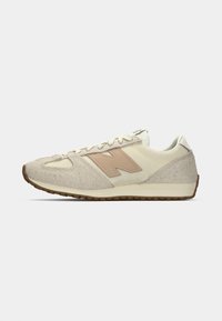 Beige- und Creme-Sneaker mit einem strukturierten Obermaterial, Mesh-Einsätzen und einem rostbraunen "N"-Logo. Gummisohle mit gemustertem Profil für guten Halt.