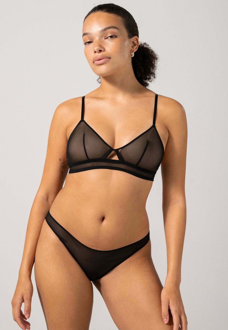 Zwarte doorschijnende lingerie set bestaande uit een triangle bralette met dunne bandjes en een decoratieve band, gecombineerd met bijpassende low-rise slipjes.