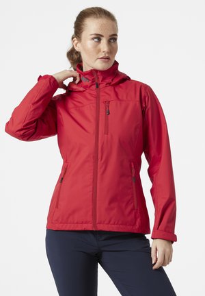 Red waterproof jacket with a zip front, adjustable hood, and two side pockets. Features a smooth texture and subtle branding.
