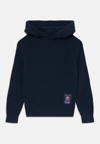 Un hoodie en maille bleu marine avec une texture côtelée, une poche kangourou et une étiquette tissée sur le côté droit à l'avant. Dispose d'une capuche structurée.