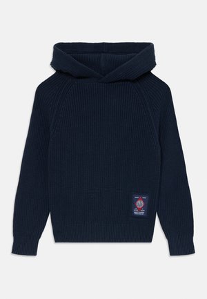 Navy blue knitted hoodie with a ribbed texture, kangaroo pocket, and a woven tag on the front right side. Features a structured hood.