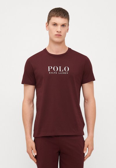 Burgundské bavlněné tričko s kulatým výstřihem a krátkými rukávy. Na přední straně je vytištěno bílé logo "POLO RALPH LAUREN".