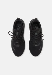 Schwarze Sportschuhe mit einem Obermaterial aus Mesh, schlankem Design, runder Zehenpartie und Gummisohle. Ausgestattet mit tonalen Schnürsenkeln und Markierungsakzenten.