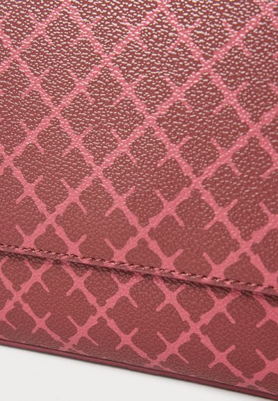 Material sintetic roz texturat cu un model geometric și forme de diamant în relief. Cusături vizibile de-a lungul marginilor.