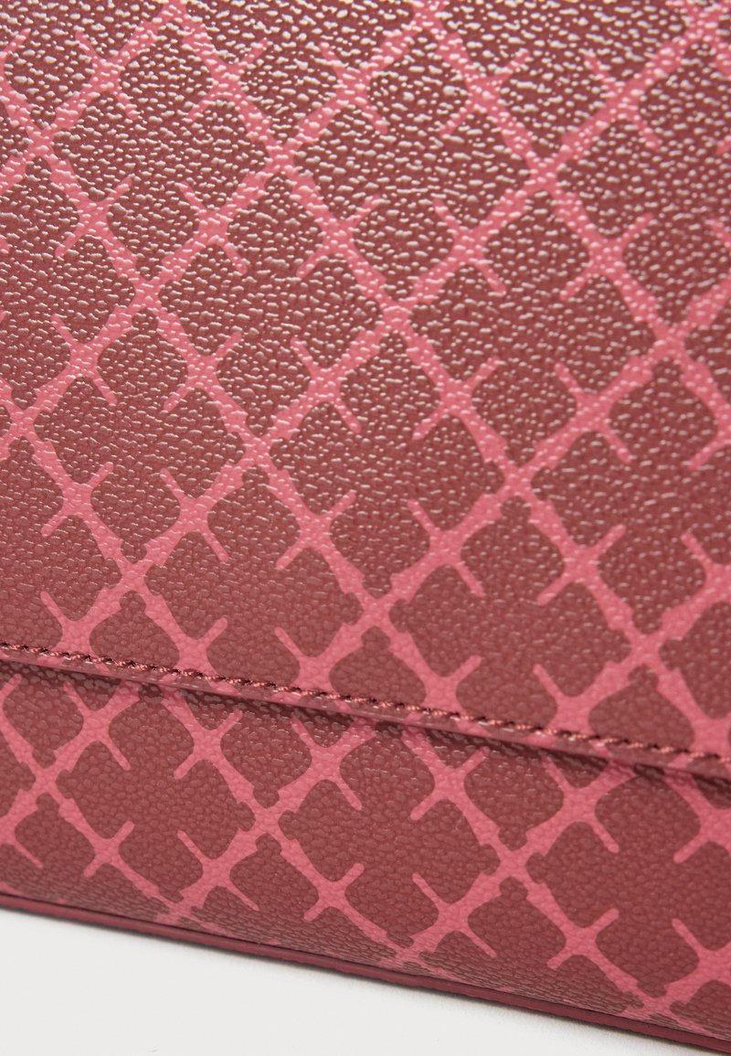 Struktureret pink syntetisk materiale med et geometrisk mønster og fremhævede diamantformede former. Synlige syninger langs kanterne.