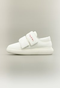 Άσπρο αθλητικό παπούτσι με μαλακούς ιμάντες με βέλκρο, στρογγυλεμένη μύτη και υφή στη σόλα. Διαθέτει κόκκινη επωνυμία «Marni» στους ιμάντες. Επάνω μέρος από λείο δέρμα.