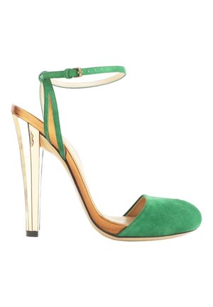 Chaussure à talon haut en daim vert avec talon bloc métallique doré et bride à boucle à la cheville, côtés ouverts et bout rond fermé.