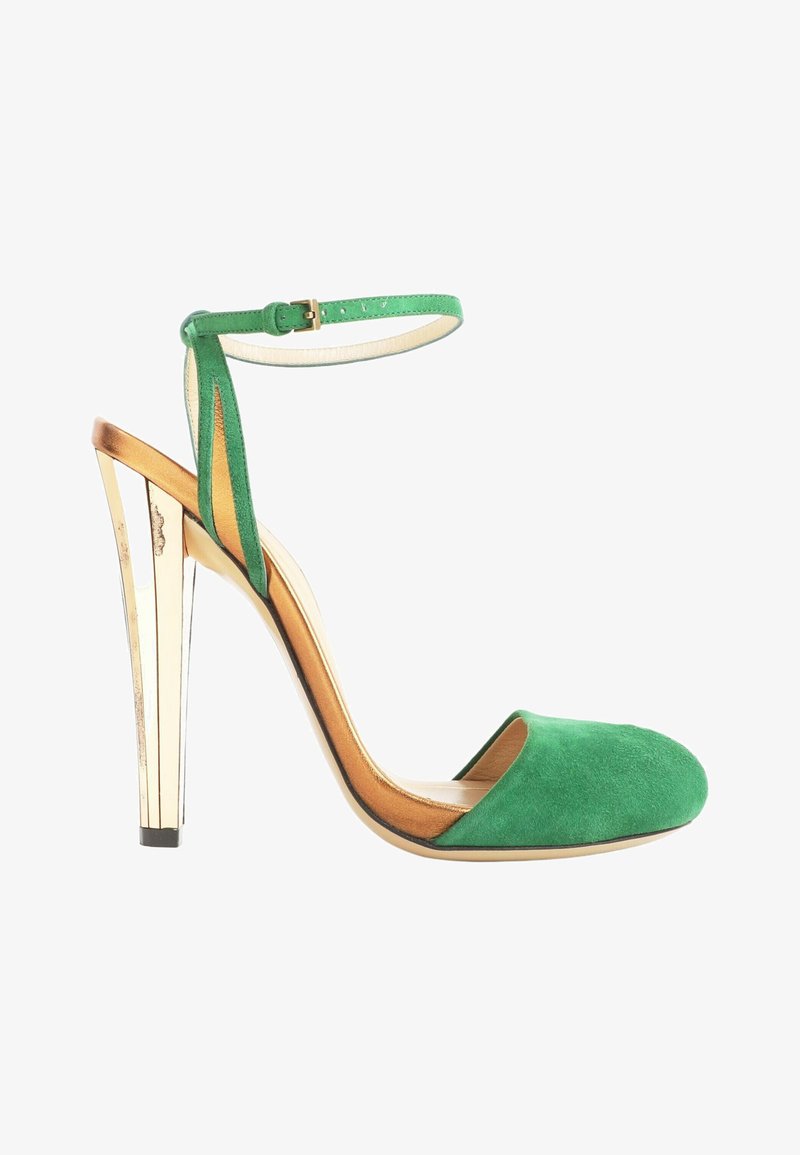 Chaussure à talon haut en daim vert avec talon bloc métallique doré et bride à boucle à la cheville, côtés ouverts et bout rond fermé.