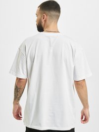 Valge puuvillane t-särk, millel on mugav lõige, lühikesed varrukad ja ümar kaelus. Sile tekstuur ning nähtavad mustrid või logod puuduvad.