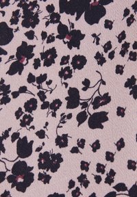 Motif floral noir avec de petits centres rose foncé dispersés sur un fond de tissu texturé rose pâle.