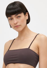 Brun bandeau-bikini topp med tynne justerbare stropper, glatt stoff, rektangulær form og minimalistisk design.