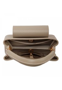 Sac à main en cuir beige avec un design structuré, doté d'une fermeture à rabat et de quincaillerie dorée. À l'intérieur, plusieurs poches pour l'organisation.