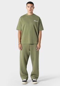 Zestaw w kolorze oliwkowym z mieszanki bawełny, składający się z t-shirtu o luźnym kroju i spodni, z krótkimi rękawami oraz prostą nogawką.