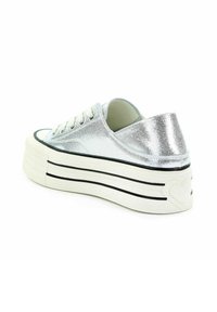 Srebrne metaliczne sneakersy na platformie z fakturowanym wykończeniem, czarną gumową podeszwą w paski i serduszkowym detalem na pięcie. Posiadają białe sznurowadła.