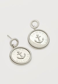 Στρογγυλά σκουλαρίκια καρφωτά σε ασημί τόνο με ανάγλυφο σχέδιο άγκυρας και κείμενο "Tommy Hilfiger" σε μενταγιόν με άκρη όπως σχοινί.