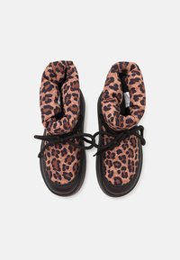 Bottes à chevilles en imprimé léopard avec des semelles en caoutchouc noir, dotées d'un col rembourré et de lacets noirs. Le matériau supérieur est doux et texturé.