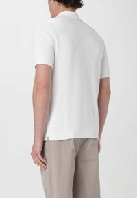 Polo a maniche corte, bianco, con un design a maglia testurizzata e polsini a costine. Ha un orlo spaccato e una vestibilità casual per il massimo comfort.