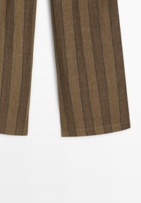 Brune vidde bukser med lodrette sorte striber, kant synlig mod en hvid baggrund.