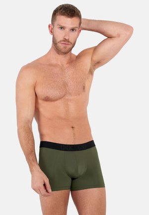 Grüne Boxer-Briefs mit einem schwarzen elastischen Bund, auf dem der Markenname steht. Sanfter, glatter Stoff mit einer passgenauen Passform und ohne sichtbare Muster.
