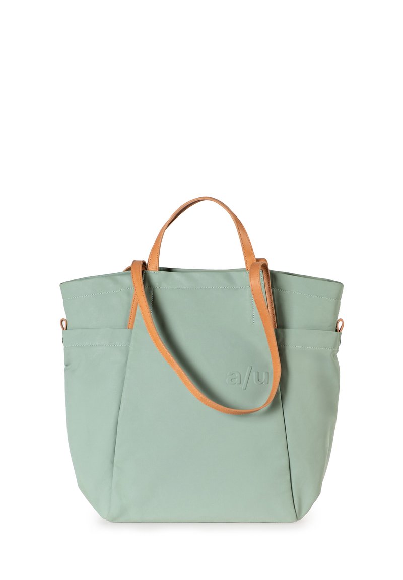 Mintgroene totebag van zacht materiaal, met tanlederen handvatten, een zijzak en subtiele reliëflogo-detail.