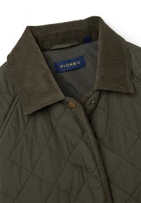 Gep quiltete olivgrüne Jacke mit dunkelbraunem Cordkragen, Druckknöpfen und einem marineblauen Etikett mit der Aufschrift "PIOMBO."