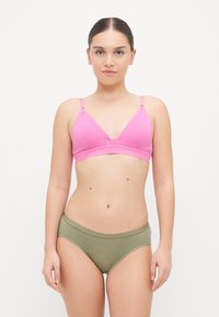Roza bombažna bralette s prilagodljivimi naramnicami in trikotno obliko, v kombinaciji z olivno zelenimi bombažnimi hlačkami, ki imajo mehek elastičen pas.