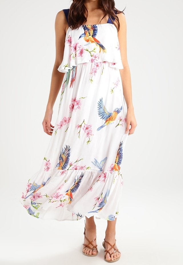 Robe longue en tissu blanc léger avec de grandes impressions colorées d'oiseaux et de fleurs. Design à plusieurs couches avec ourlet à volants et bretelles bleu marine.