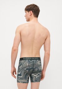 Μαύρες μποξέρ ανδρικές μαθές με μαρμάρινο σχέδιο σε πράσινο και γκρι, διαθέτοντας φαρδύ ελαστικό ζωνάκι με λογότυπο "BJÖRN BORG" και εφαρμοστή σχεδίαση.