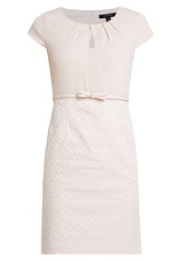 Robe rose clair avec manches courtes, corsage plissé et jupe texturée présentant un motif géométrique subtil. Accentuée par une ceinture en tissu.