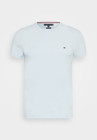 Hellsblaues Baumwoll-T-Shirt mit kurzen Ärmeln, Rundhalsausschnitt und einem kleinen gestickten Logo auf der linken Brust. Glatte Textur, lässiges Design.