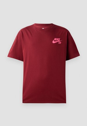 Burgundy cotton t-shirt with short sleeves, round neck, and pink Nike SB logo on the left chest. Soft texture, casual fit.