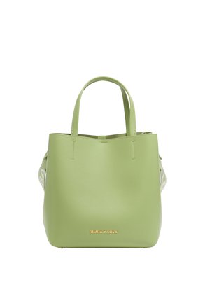 Green leather tote bag with a smooth texture, sturdy handles, and a gold logo at the bottom. Features a minimalist design and open top.