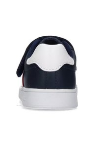 Sneaker in pelle blu navy con suola in gomma bianca, dotato di un tallone testurizzato e di un cinturino in Velcro per una chiusura facile.