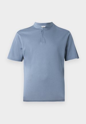Short-sleeve shirt in light blue fabric with a half-button placket and a mock collar, featuring a smooth texture and clean lines.