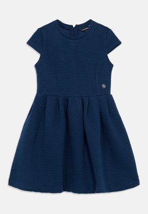 Abito blu navy in tessuto textured con maniche corte, corpetto aderente e gonna a ruota. Caratterizzato da una cerniera posteriore e un piccolo dettaglio logo sul lato.