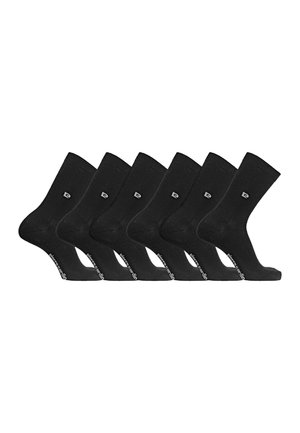 Six paires de chaussettes noires montantes avec un petit logo près de la cheville et une marque sur la semelle, disposées côte à côte sur fond blanc.