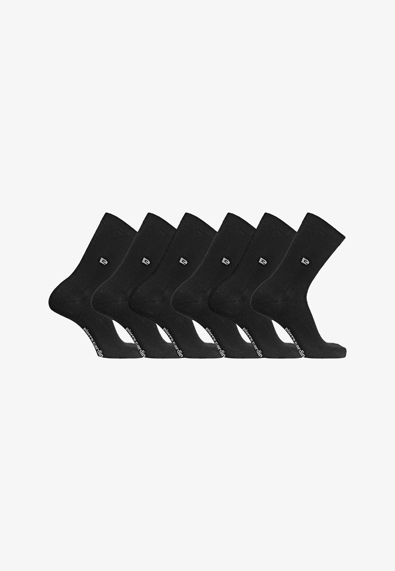 Six paires de chaussettes noires montantes avec un petit logo près de la cheville et une marque sur la semelle, disposées côte à côte sur fond blanc.