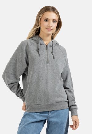 Felpa con zip grigia in tessuto morbido, dotata di cappuccio con cordino, maniche raglan e polsini e orlo a coste. Abbinata a jeans blu.