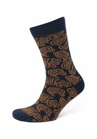 Marineblaue Socken mit einem wirbelnden goldenen Muster, ribbelndem Bündchen und glatter Textur. Die Socken haben eine Standardlänge und eine verstärkte Ferse.