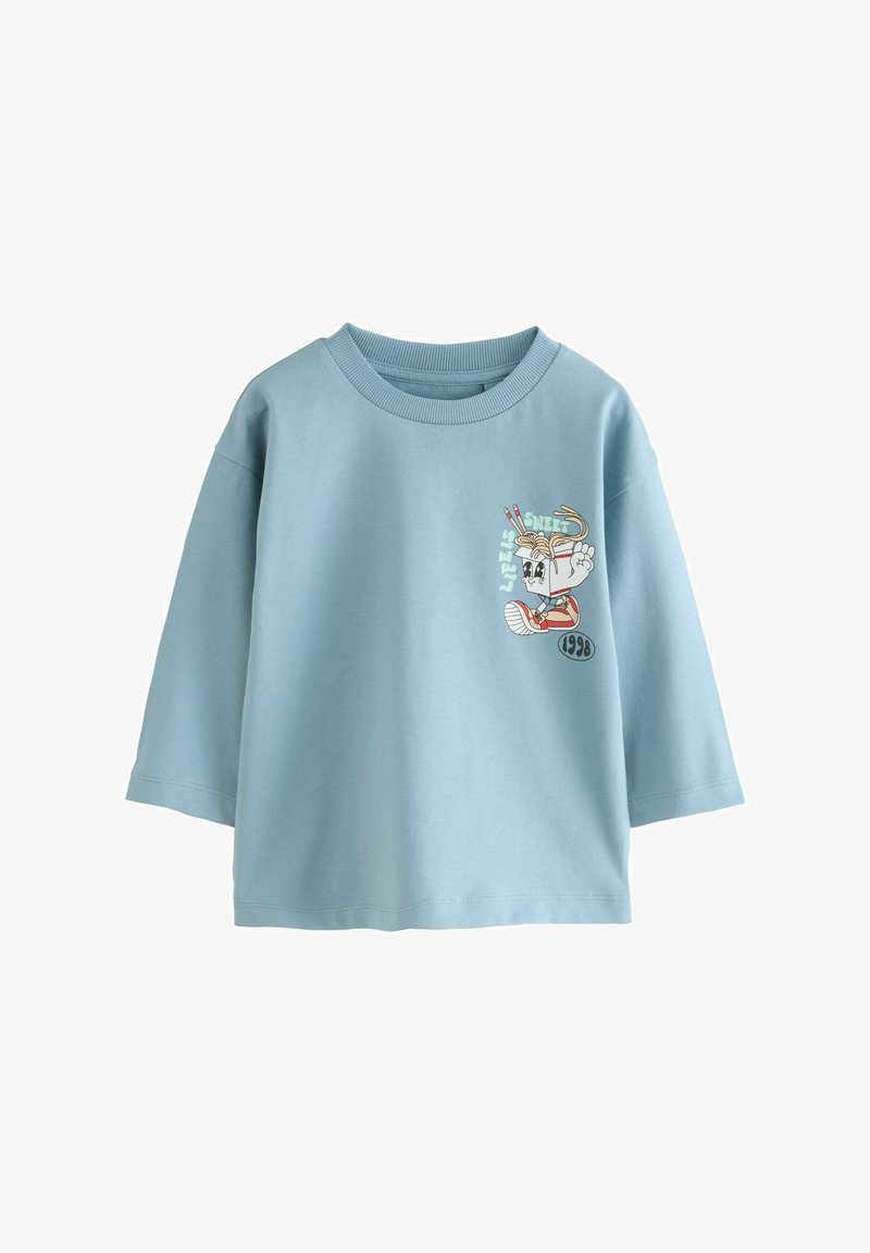 Camiseta de algodón azul claro con cuello redondo y mangas cortas. Presenta un diseño gráfico de un personaje de dibujos animados con texto y detalles.