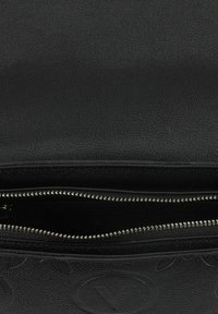 Zwarte leren tas met een textuurafwerking, voorzien van een fijne ritssluiting en een zichtbaar interieurvak in de opening.