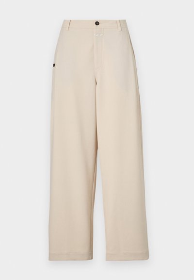 Beige wijde broek gemaakt van zachte stof, met een sluiting met voorknop, zijzakken en een relaxte pasvorm.