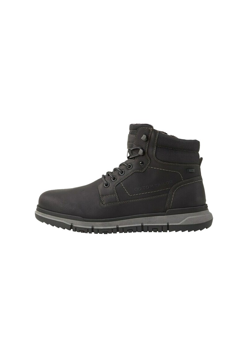 Botas de tobillo de cuero negro con un cuello acolchado, diseño de cordones, suela de goma gris y detalle de logo en el lateral. Presenta costuras reforzadas.