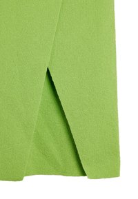 Zielona tkanina frotte z teksturowanym, chłonnym wykończeniem. Posiada złożony róg, tworząc kanciasty wzór o jednolitym, żywym kolorze.