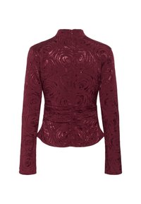 Burgundská bunda s květinovou texturou, dlouhými rukávy, vysokým límcem a přiléhavým střihem; má zadní zip a nařasené detaily v oblasti pasu.