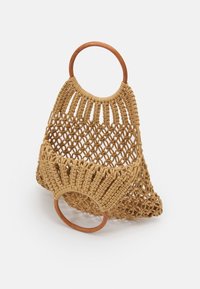 Panier tressé beige avec poignées en anneau en bois. Présente un design à treillis ouvert et un fond arrondi. Finition texturée, construction légère.