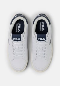 Białe sneakersy z gładką, syntetyczną cholewką i granatowymi akcentami. Cechy obejmują sznurowaną konstrukcję, wyprofilowany kołnierz i logo Fila na języku.