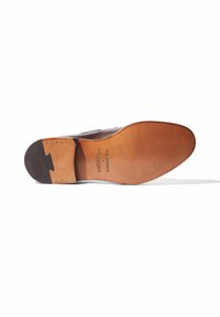 Bruine leren schoen met een gladde afwerking, voorzien van een contrasterende tan zool, gegraveerd merk en decoratieve stiksels. Maat 42.