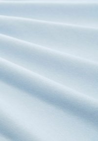 Világoskék pamut szövet, sima textúrával, lágy, folyó redőkkel és egységes színnel. Kiválóan alkalmas különböző textil alkalmazásokhoz.